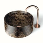 Round brown marble vessel sink with bronze faucet